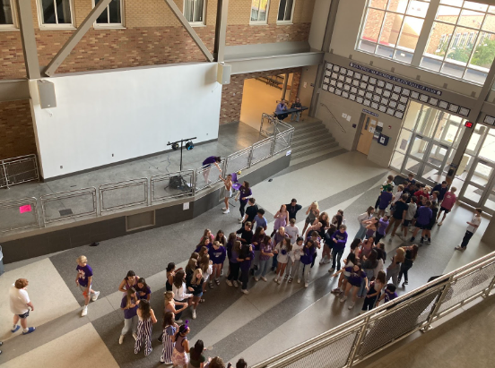 Dancers meet up in the Commons in their purple attire. 